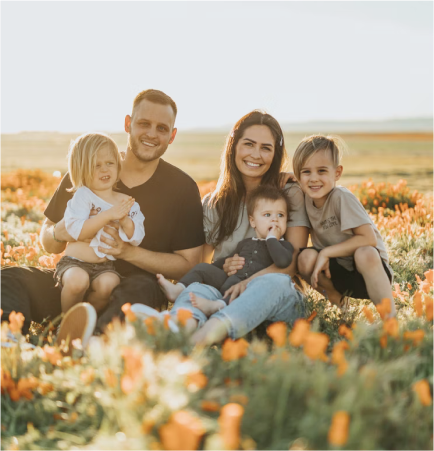 Young family smiling in a field of flowers